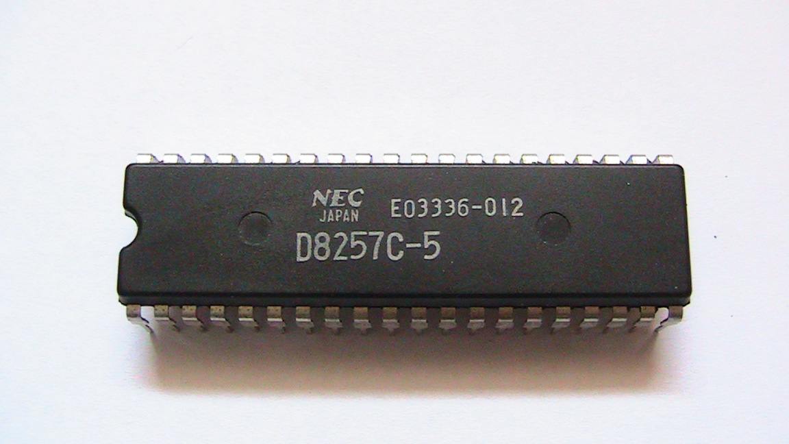 A black 40-pin DMA controller chip on a green circuit board