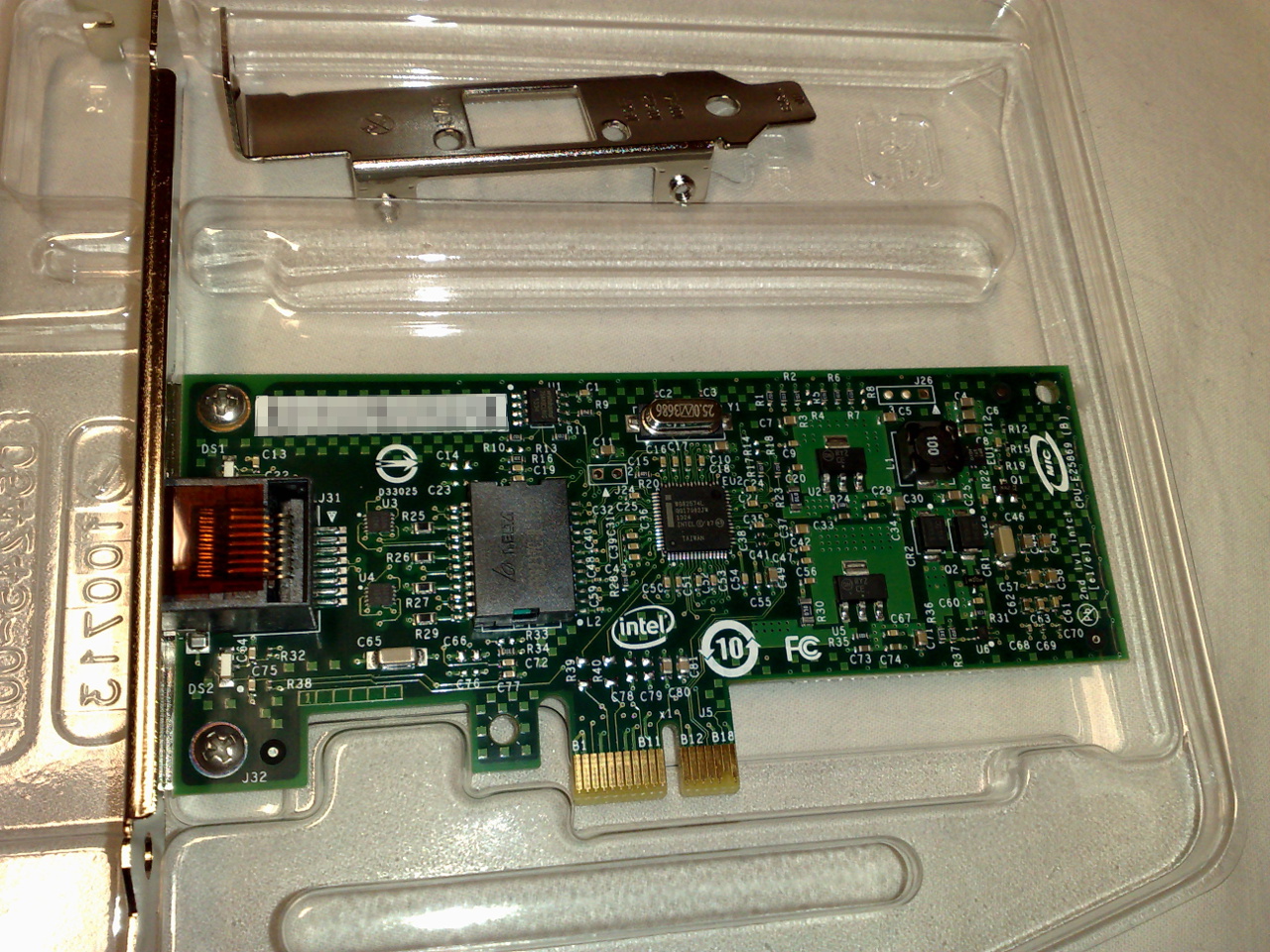Green PCI Express x1 Intel Gigabit network card in a plastic tray, with an RJ45 socket on the left and a gold connector at the bottom