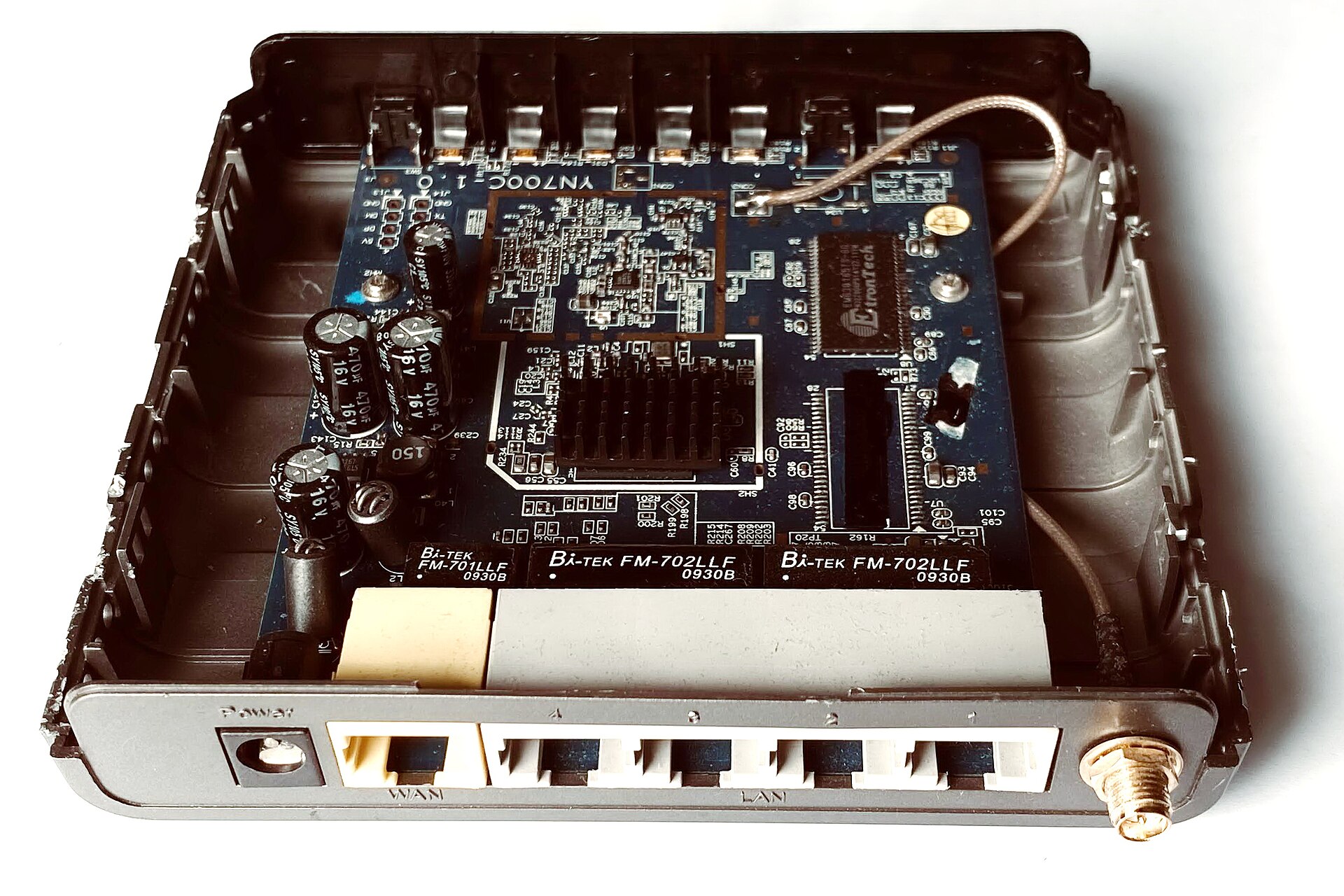 The inside of a small Wi-Fi router, a circuit board with chips and antenna wires